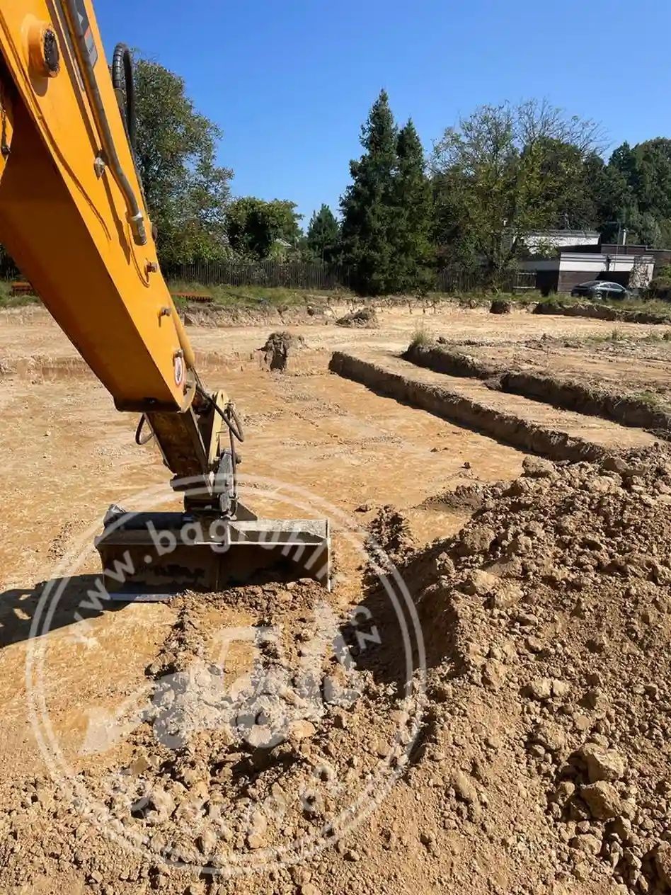 Traktor-bagr JCB při výkopových pracích základových pásů v Krmelíně
